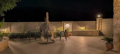 a patio with chairs and a fence at night at Achlades The Mountain Paradise Villas - Maisonette with pool and amazing view! in Aletrouvárion
