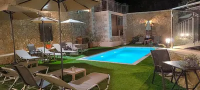 a swimming pool in a yard with chairs and an umbrella at Achlades The Mountain Paradise Villas - Maisonette with pool and amazing view! in Aletrouvárion