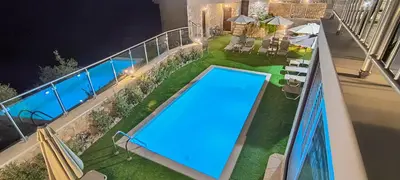 an outdoor swimming pool on a balcony at night at Achlades The Mountain Paradise Villas - Maisonette with pool and amazing view! in Aletrouvárion