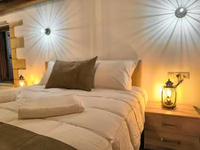 a bedroom with a white bed with a lamp on a table at Achlades The Mountain Paradise Villas - Maisonette with pool and amazing view! in Aletrouvárion