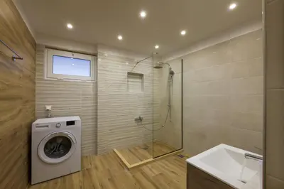 a bathroom with a washing machine and a shower at Callista City Living III in Chania Town