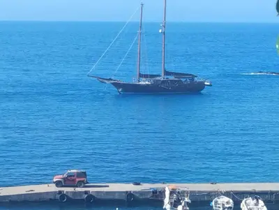 a sail boat in the water with a red truck at Sweet Corner Masxali in Agia Roumeli