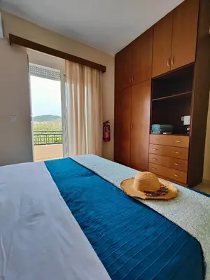 a bedroom with a bed with a straw hat on it at Bellavista Gardens Skoutelonas in Skoutelónas