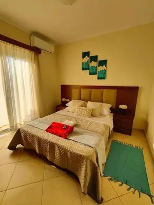 a bedroom with a bed with a red bag on it at Bellavista Gardens Skoutelonas in Skoutelónas