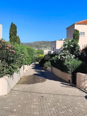 a brick road with bushes and trees on the side at Bellavista Gardens Skoutelonas in Skoutelónas