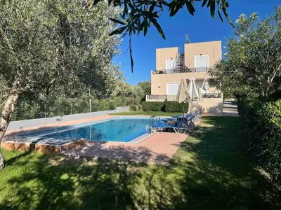 a villa with a swimming pool in front of a house at Bellavista Gardens Skoutelonas in Skoutelónas