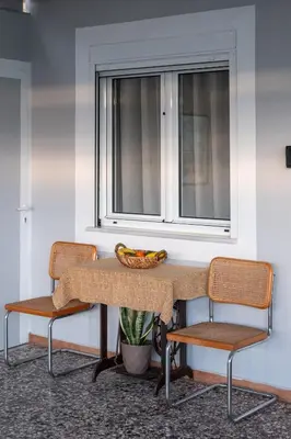 a table and two chairs in front of a window at Haris home in Daratso