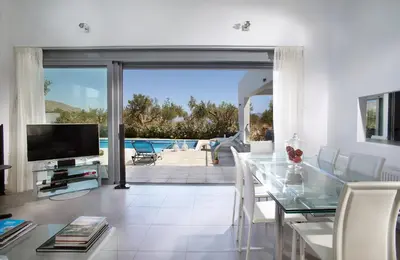 a living room with a glass table and a television at Gramvousa Villas in Kissamos
