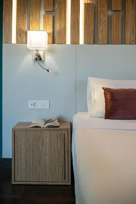 a bedroom with a bed and a lamp on a night stand at Elia Bettolo Hotel in Chania Town