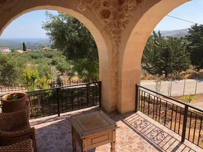 an outdoor patio with an archway and a table at Villa Aris in Crete with private pool en private parking! in Neo Chorio