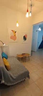 a bedroom with a bed and a table and paintings at Color Living in Chania Town