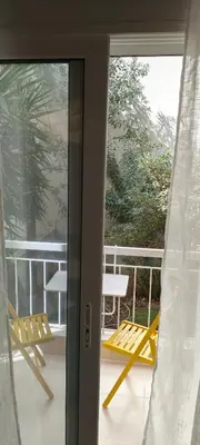a sliding glass door with two chairs on a balcony at Color Living in Chania Town