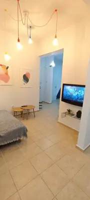 a living room with a large flat screen tv at Color Living in Chania Town
