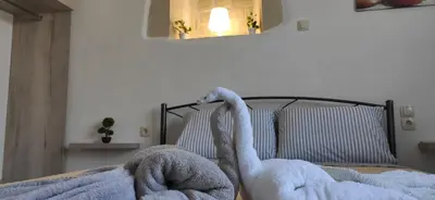 two swans sitting on a bed in a bedroom at Bee studio in Gavalochori