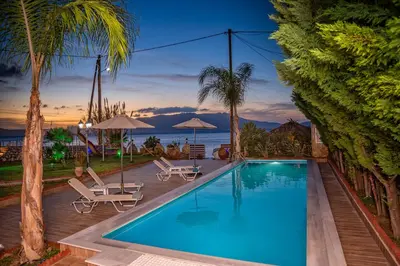 a swimming pool with two lounge chairs and a resort at Julia's Cosy Apt in Ravdhoúkha