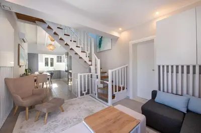 a living room with a staircase and a table at Villa Mareli - Beachside Villa with Heated Pool in Almirida