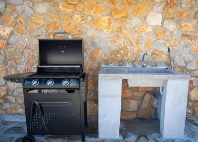 a stove with a laptop on top of it next to a stone wall at Villa Pervana- Private pool - Close to the Beach in Arménoi