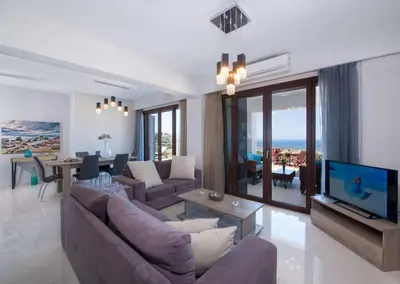 a living room with a couch and a tv at Marilia by Vintage Travel in Maleme