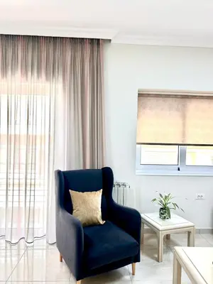 a living room with a blue chair and a window at Nerina Home Chania in Chania Town