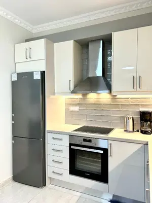 a kitchen with white cabinets and a stainless steel refrigerator at Nerina Home Chania in Chania Town
