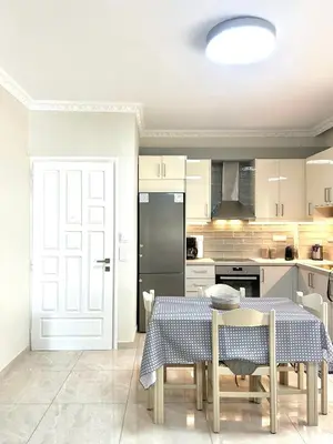 a kitchen with a table and a black refrigerator at Nerina Home Chania in Chania Town
