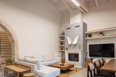 a living room with a couch and a fireplace at Artemis Apollonas Villa I Luxury Escape with Pool in Káïna