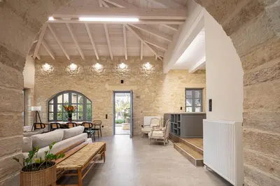 an open living room with a stone wall at Artemis Apollonas Villa I Luxury Escape with Pool in Káïna