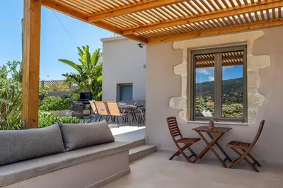 a patio with a couch and chairs and a table at Villa Eva Chania in Neo Chorio