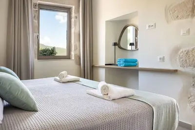 a bedroom with a bed with towels and a mirror at Villa Eva Chania in Neo Chorio