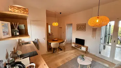a living room with a table and a tv at Kalimera Kalyves Apartment in Kalyves