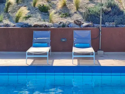 two blue and white chairs next to a swimming pool at Bellavista Panorama Darmarochori in Darmarochori