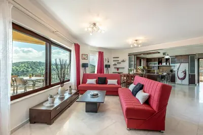 a living room with red furniture and a large window at Sunlit sea view apartments in Stalos