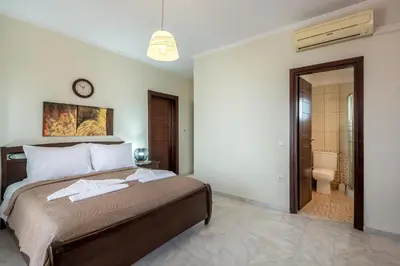a bedroom with a bed and a bathroom at Sunlit sea view apartments in Stalos