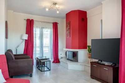 a living room with red curtains and a tv at Sunlit sea view apartments in Stalos