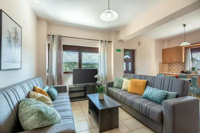 a living room with a couch and a tv at Sunlit sea view apartments in Stalos