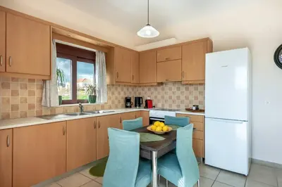 a kitchen with a table and a white refrigerator at Sunlit sea view apartments in Stalos