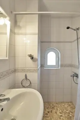 a white bathroom with a sink and a shower at Elaiona Country Home in Xamoudhokhórion