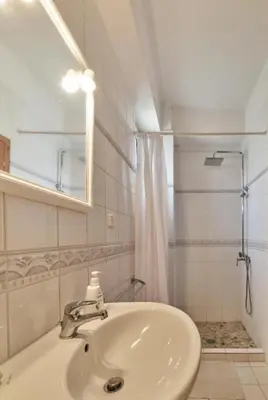 a white bathroom with a sink and a shower at Elaiona Country Home in Xamoudhokhórion