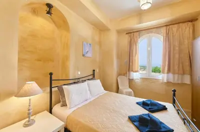 a bedroom with a bed and a window at Elaiona Country Home in Xamoudhokhórion