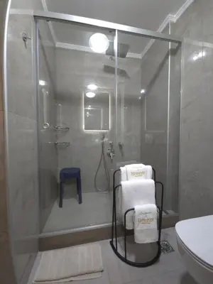 a bathroom with a shower with a glass door at Breeze Apartment in Chania Town