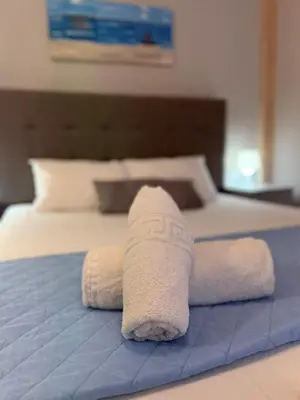 a white towel laying on top of a bed at Dom Suites in Aghii Apostoli