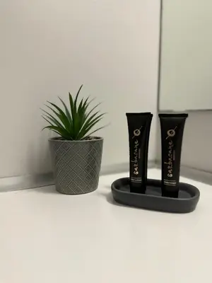 two black vases sitting next to a potted plant at Dom Suites in Aghii Apostoli