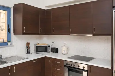 a kitchen with wooden cabinets and a microwave oven at Villa Kimi -New listing with sea views! in Kalyves