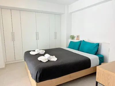 a bedroom with a large bed with towels on it at Azure Loft - 3min walk to beach, 10min to Old Town in Chania Town