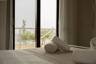a bed with a pile of towels on top of it at Terra Blue Suites - Nefeli in Kalyves