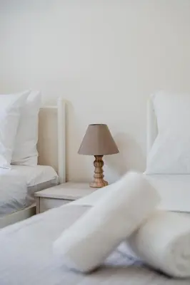 a bedroom with two beds and a lamp on a table at Terra Blue Suites - Nefeli in Kalyves
