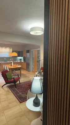 a living room with a table and chairs and a lamp at La Casa di Corina in Kato Daratso