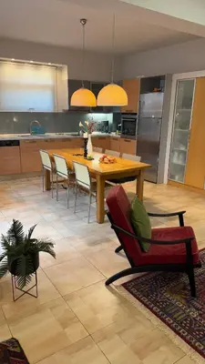 a kitchen with a wooden table and chairs in a kitchen at La Casa di Corina in Kato Daratso