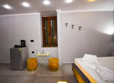 a bedroom with a bed and a table and a window at Vasiliki Venetian suites in Chania Town