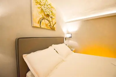 a bedroom with a bed and a painting on the wall at Vasiliki Venetian suites in Chania Town